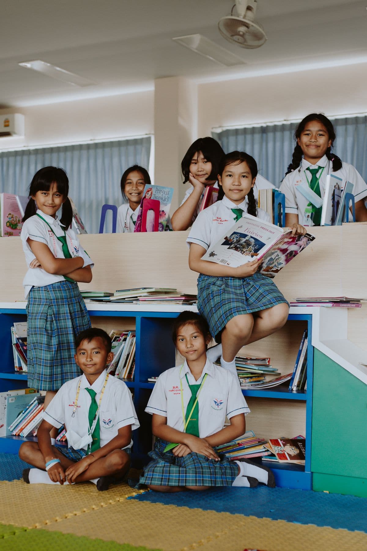 A group of primary students in school uniform together in a reading room